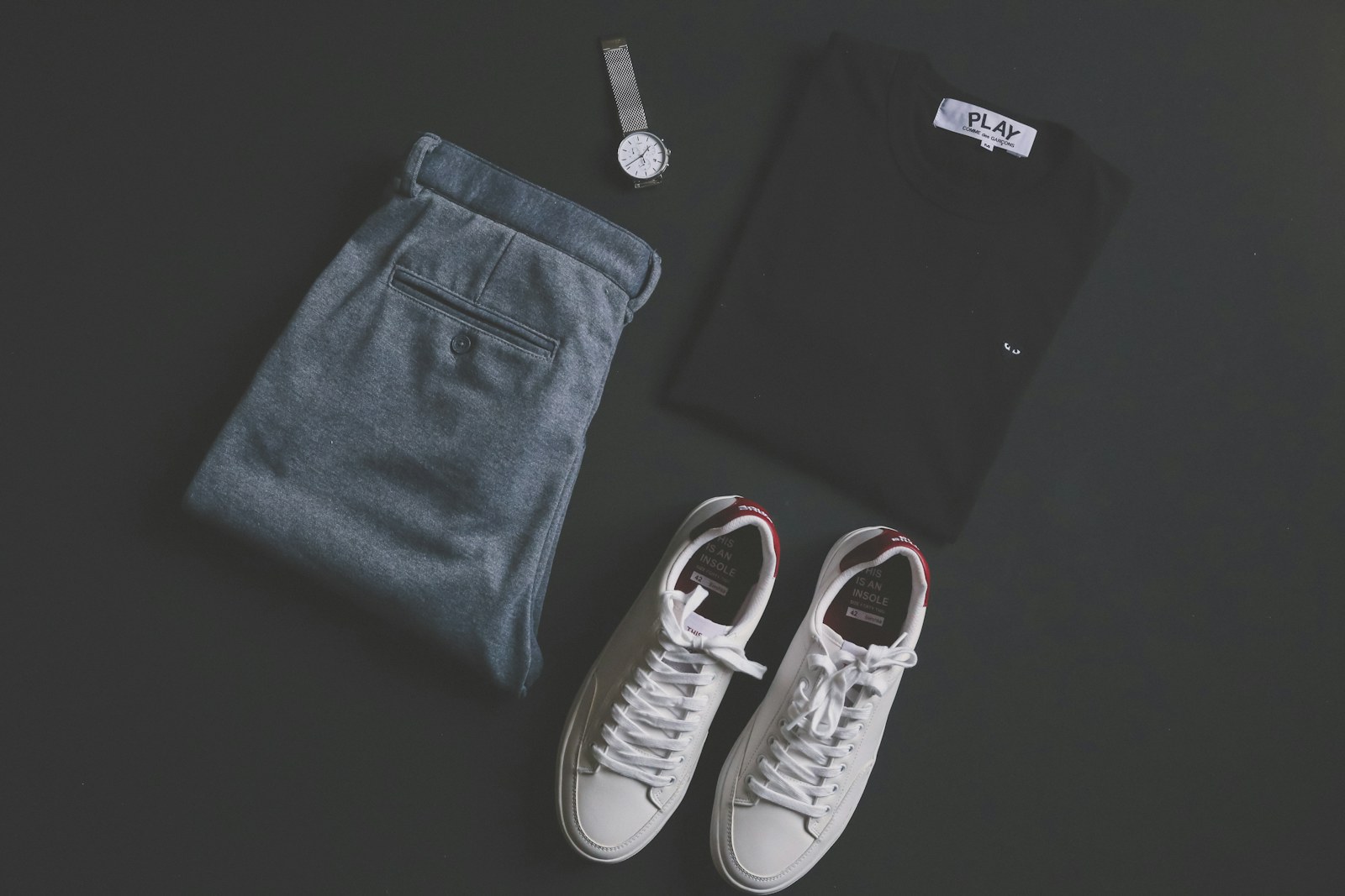 Jeans, a shirt and white trainers arranged together